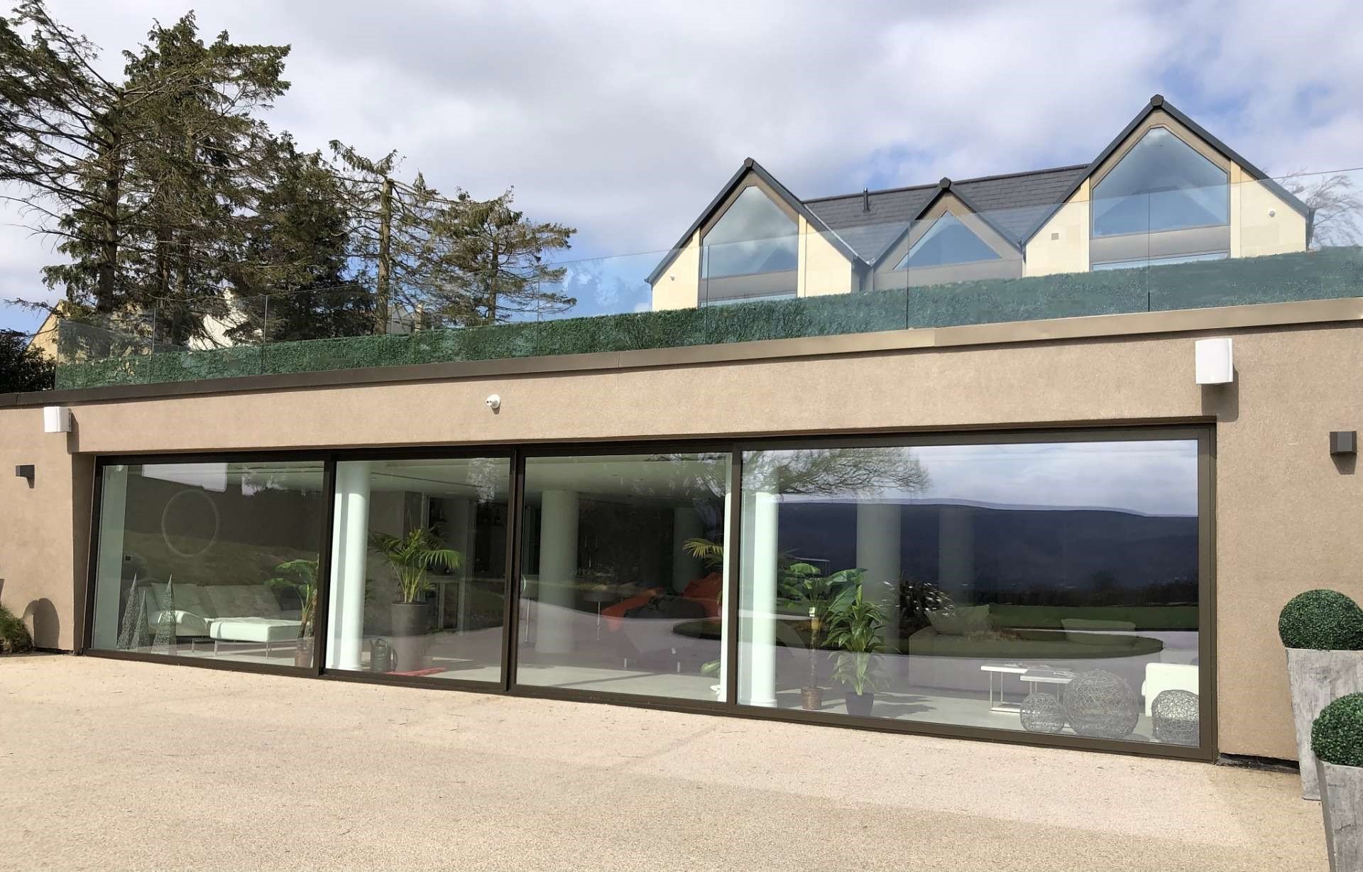 Large scale aluminium sliding doors and aluminium shaped feature glazing in Ilkley New build