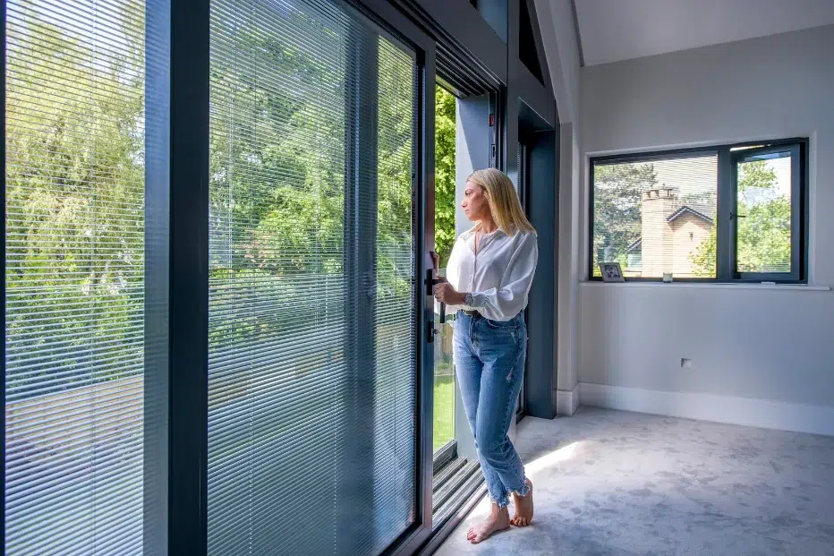 lady opening sliding patio door fitted with integral blinds